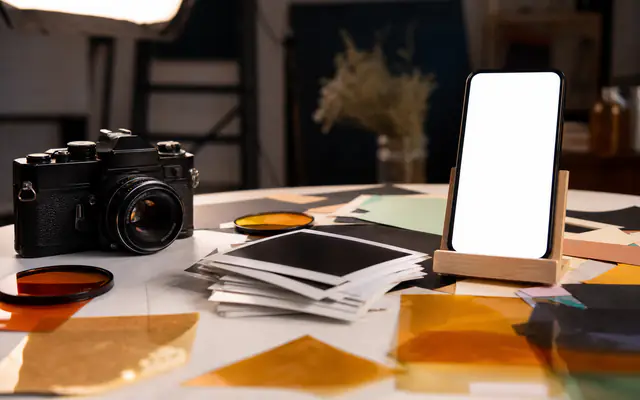 Creative studio table with camera, amber gels, and blank photo prints